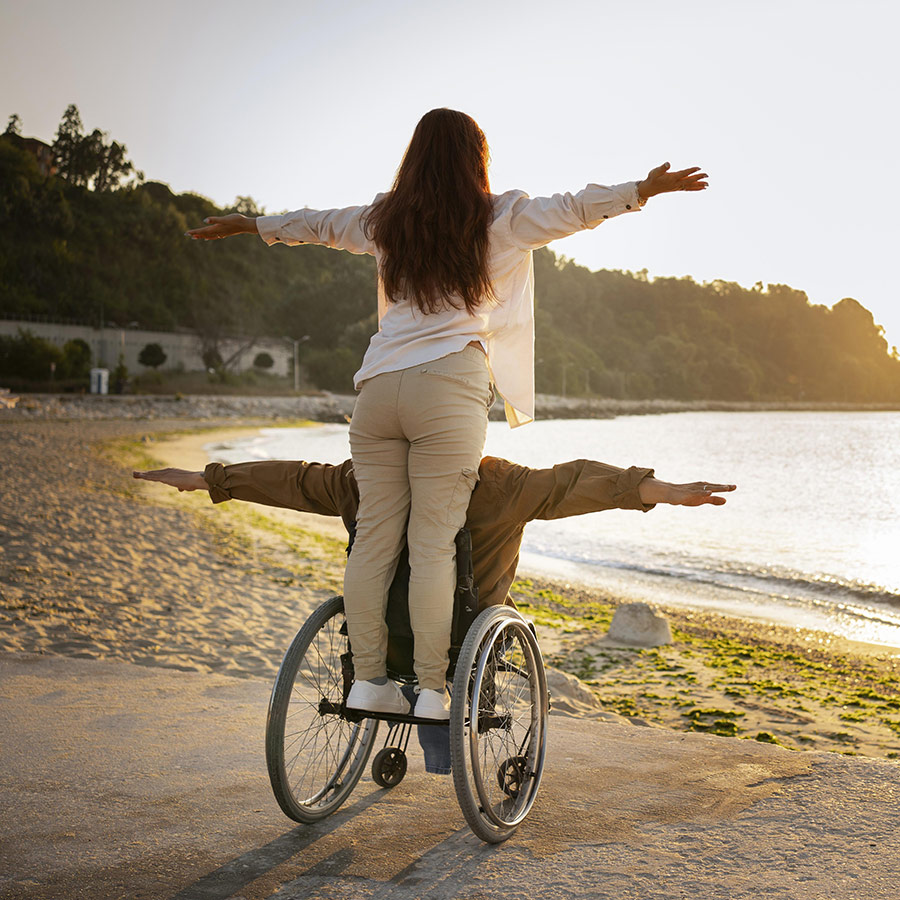 Man in wheel chair with woman on back with arms out