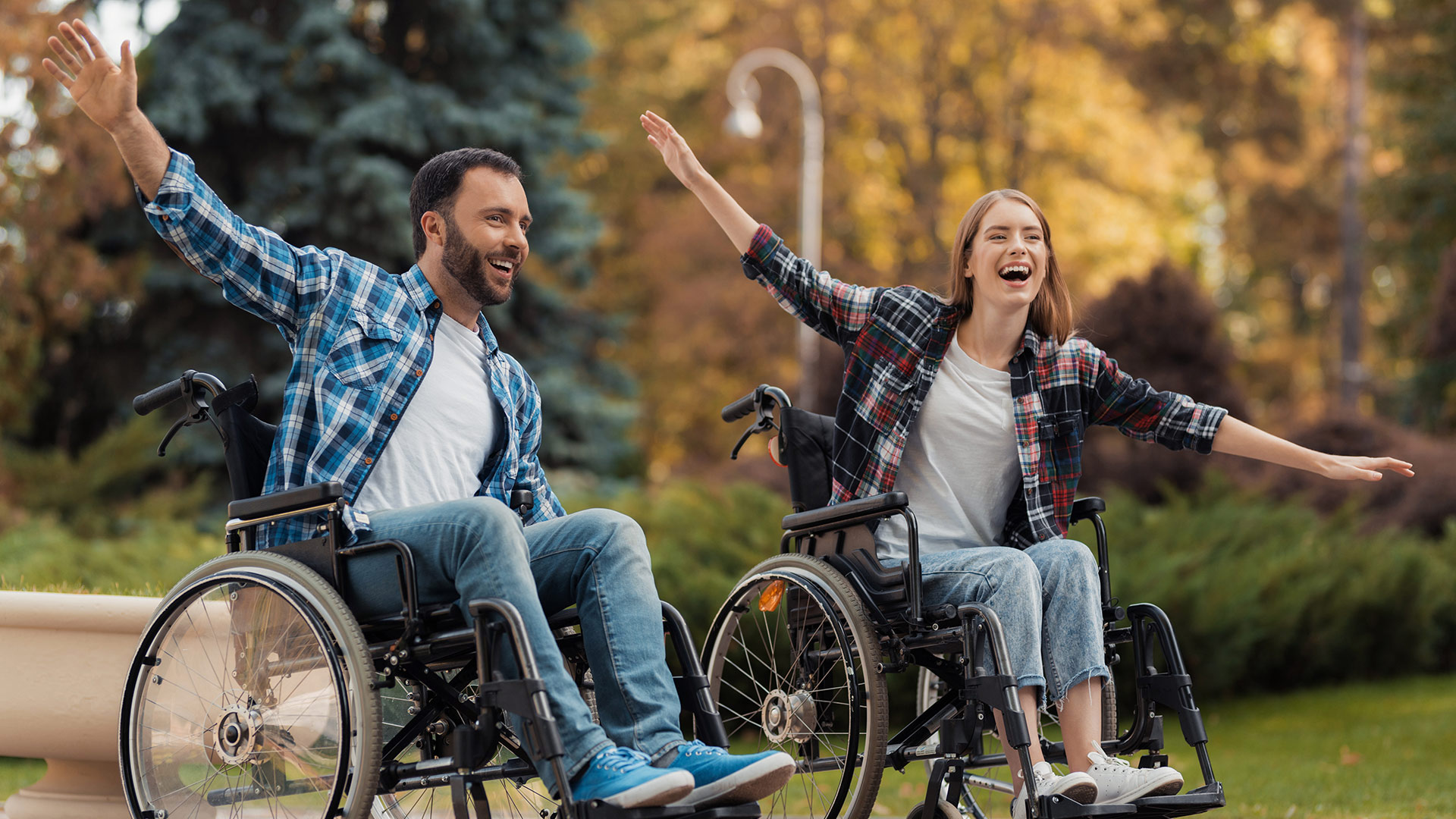 Couple in wheel chairs having fun in a park