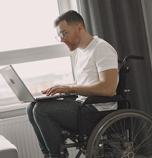Man using laptop in wheelchair